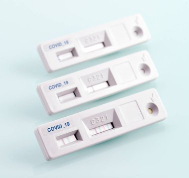 Yukarıdan küçük beyaz cihazlar hızlı hastalık tespiti için açık mavi arkaplan üzerine yerleştirilmiş