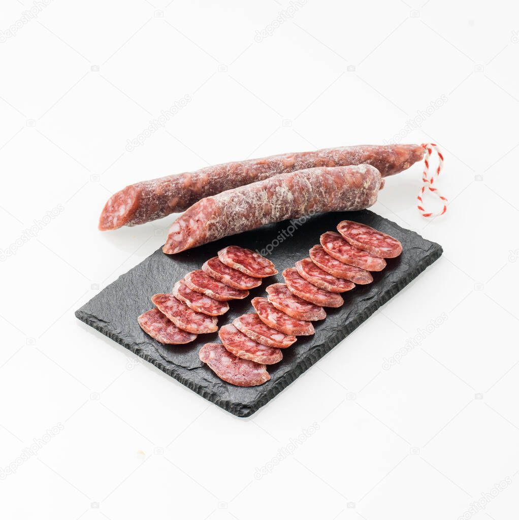 From above rows of tasty pieces of pork cured sausage isolated on white background