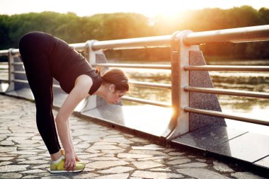 Gün batımında yaz aylarında göl Şehir Parkı germe yapıyor güzel genç kız