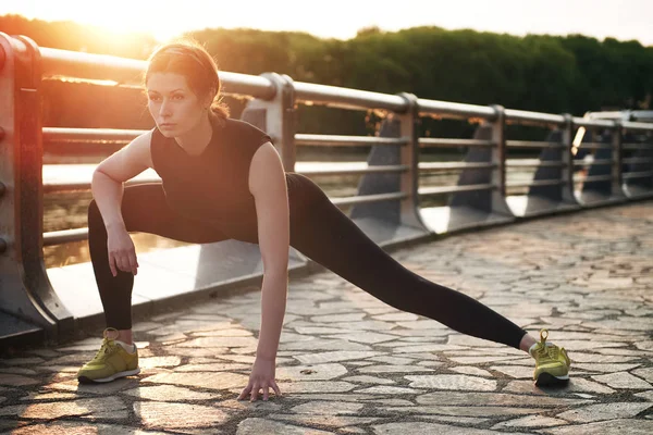 Yong Läuferin mit schöner Figur macht Dehnübungen vor ihrem Lauf — Stockfoto