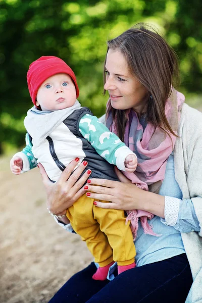 Young and happy mother cares for her young son and played with him in the summer in the park. family Concept — Stock Photo, Image