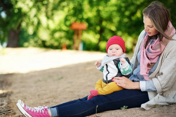 Fiatal és boldog anya fiát ápolja, és játszott vele a nyáron a parkban. a család fogalma — Stock Fotó