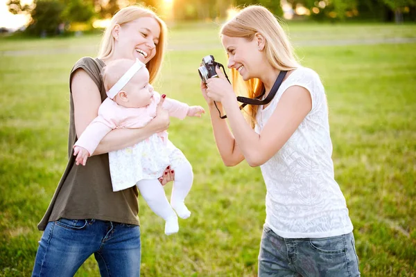 2 つの若い母親は自分の赤ちゃんと夏の公園で歩いています。Lgbt レズビアン カップル。家族や健康的なライフ スタイルのコンセプト — ストック写真