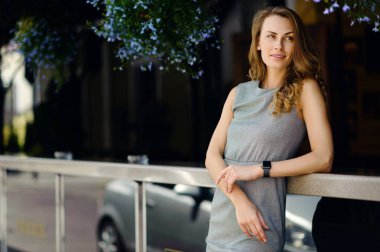 Genç ve Teras çiçek ile yakın duran ve gülümseyen güzel kız