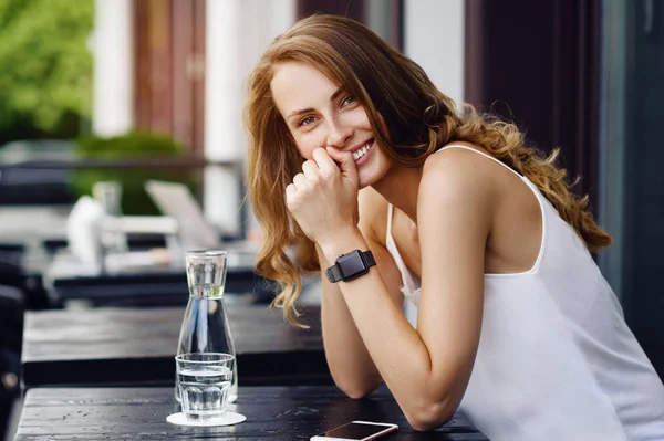 Bir yaz kafede oturan ve gülümseyen güzel kız. Akıllı el saatler — Stok fotoğraf