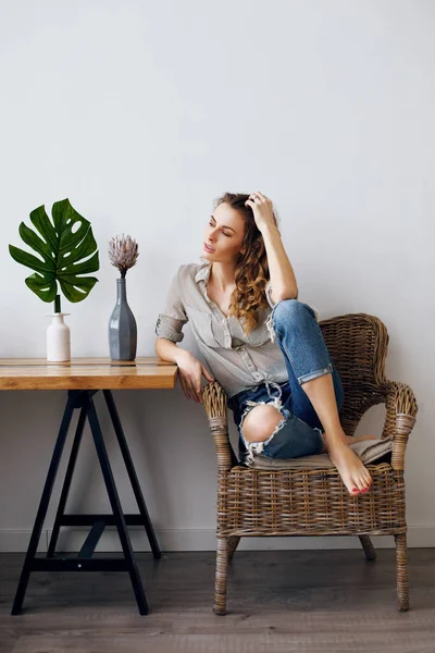 El concepto de un estilo de vida. Joven hermosa chica está sentado en una silla en la mesa en casa — Foto de Stock