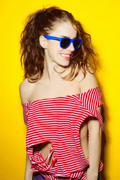 Bella giovane ragazza sexy in occhiali da sole blu e una T a strisce rosse — Foto Stock