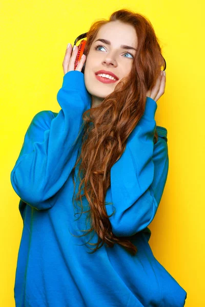 青色の美しい若いセクシーな女の子 Dj ジャケット イエロー バック グラウンドを有し楽しみに赤いヘッドフォンで音楽を聴く — ストック写真