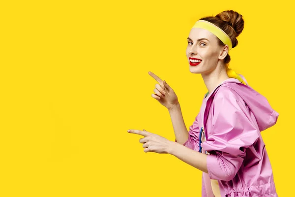 黄色背景和粉红色大衣的年轻女子。色彩痴迷的概念。简约风格。时尚时尚 — 图库照片