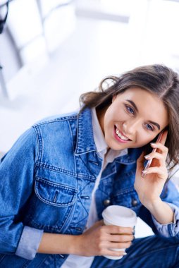 Hippi kadın ofiste konuşuyor ve kahve içiyor..