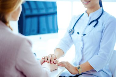 Doktor ve hasta. Ellerini masaya koy. Doktor ve hasta masada otururken bir şey tartışıyorlar. İlaç ve sağlık hizmetleri kavramı.