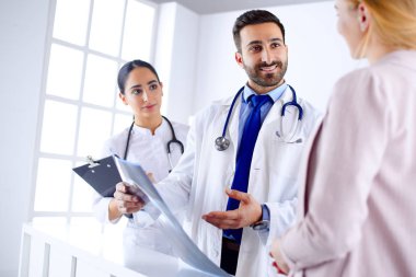 Genç Arap doktor hastanedeki bir hastaya teşhisi açıklıyor.