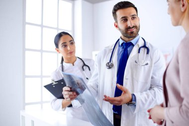 Genç Arap doktor hastanedeki bir hastaya teşhisi açıklıyor.
