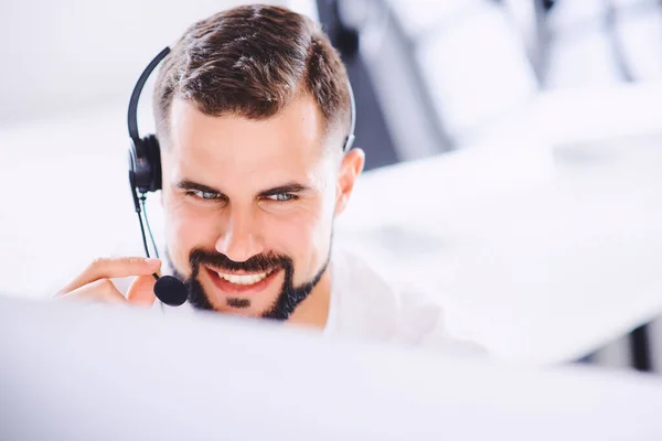 Młody Uśmiechnięty Operator Obsługi Klienta Słuchawkami Głośnomówiącymi Pracującymi Biurze Pojęcie — Zdjęcie stockowe