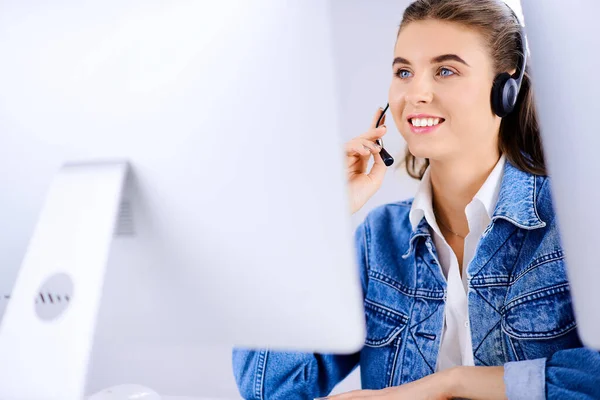 Female technical support agent in office working on computer