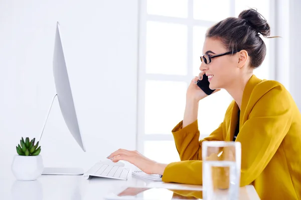 Jovem Mulher Negócios Falando Telefone Enquanto Estiver Usando Desktop — Fotografia de Stock