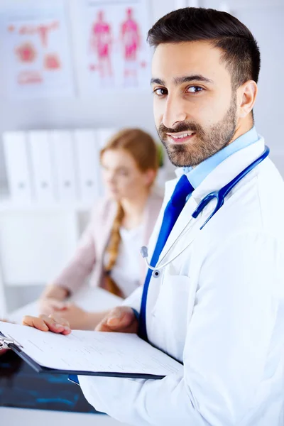 Medico Arabo Sorridente Ufficio Con Tablet Stetoscopio Paziente Sullo Sfondo — Foto Stock