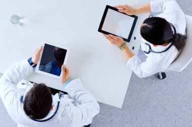 Düz yerde, üst tarafta. Hastanedeki profesyonel doktorlar tabletleri tabletlerle masaya oturtuyorlar. Hastanedeki bir grup doktor 