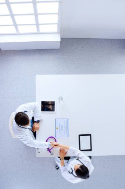 Üst manzara, düz yatak, ofiste el sıkışan iki müslüman doktor, diploma, steteskop, hastane, muayene