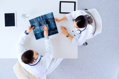 Omurga röntgeni ve hastane, tıp, sağlık ve cerrahi konseptinde panosu olan doktor veya cerrah 