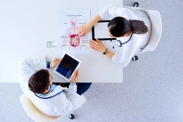 Doktorlardan Oluşan Bir Ekip Masada Oturup Tabletlerle Insanlar Hakkında Tartışıyor — Stok fotoğraf