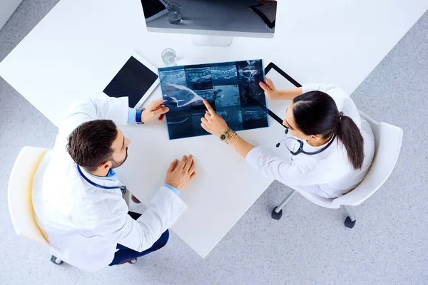 Doktorlardan Oluşan Bir Ekip Masada Oturup Tabletlerle Röntgenleri Tartışıyor — Stok fotoğraf
