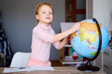 Kafkasyalı genç bir kız evinde toprak küreye bakıyor. Öğrenci kız ödev yapıyor ve dünyaya bir şeyler gösteriyor.