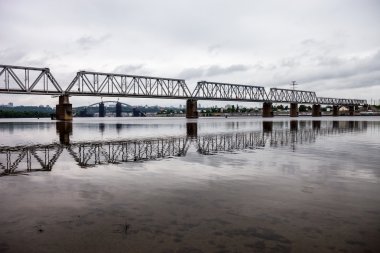 Kyiv 'deki Petrivskiy Demiryolu Köprüsü (Ukrayna) bulutlu bir günde nehrin sol kıyısından Dinyeper Nehri' nin karşı kıyısından ateş açtı.,