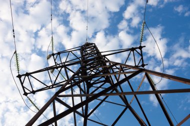 Bulutlu gökyüzü arka planına karşı elektrik direği.