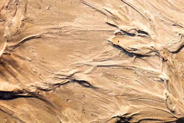 Sand surface after the rain with the relief formed by water currents.