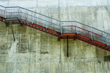 Gri beton duvardaki metal merdivenler..