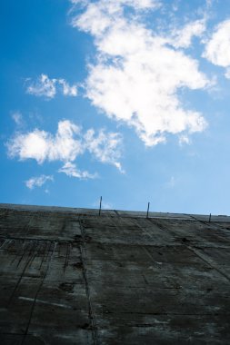 Beyaz bulutlar ile mavi gökyüzü gri beton duvara.