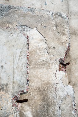 Metal döngüler ve zengin doku, gri beton bloklarla yakın çekim.