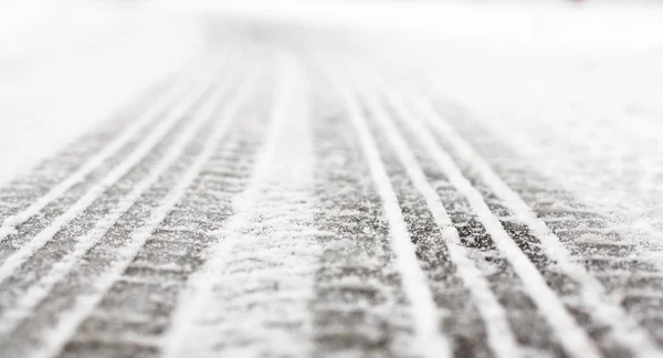 Wheel tracks on the road covered with snow — Stock Photo, Image