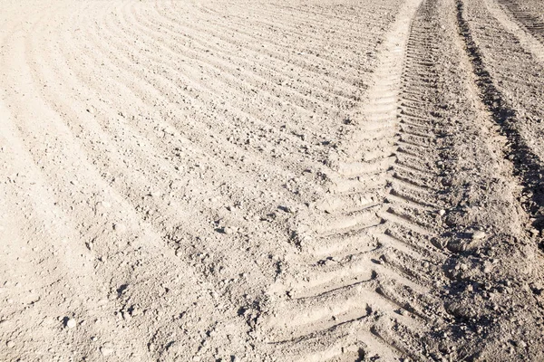 Pistes de roues sur le terrain labouré — Photo