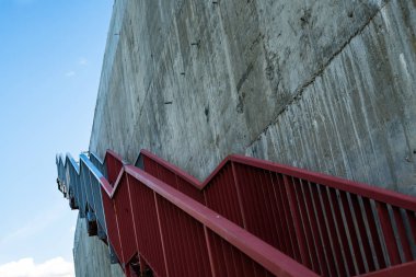 Gri beton duvardaki metal merdivenler.