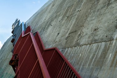 Gri beton duvardaki metal merdivenler.