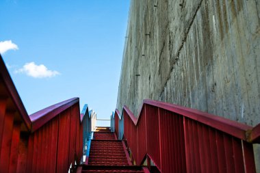 Gri beton duvardaki metal merdivenler.