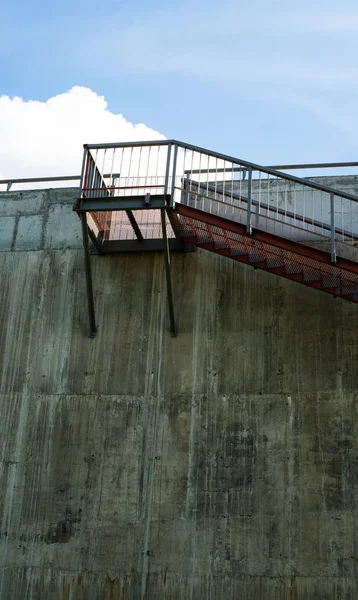 Metal stairs on the gray concrete wall