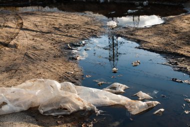 Toprak yoldaki çamurda çöp..