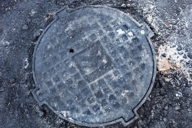 Asfalt yüzeyinde metal kaplamalı rögar deliği