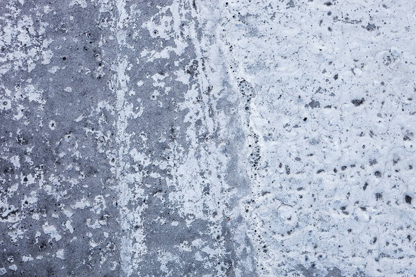 Partly whitewashed concrete wall with rich and various texture.