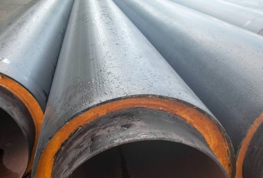 Bir yığın yeni gri boru (tüpler). Sıvı taşıma. Boru hattı yapımı.