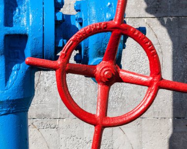 Mavi boruda kırmızı vana var. Tekerlek saplı vana. Endüstriyel. Yakın plan..