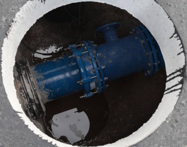 Beton blokta rögar kapağı açın. Rögardaki mavi boru. İnşaat alanı.