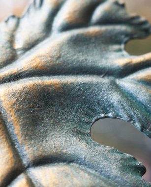 Metal üzüm yaprağı. Sahte süs. Bronz rengine boyanmış. Yakın plan..