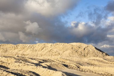 Caterpillar izleri bulutlu gökyüzü karşı olan kum yığınları.