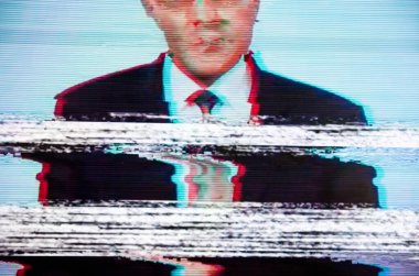Ekranda takım elbiseli bir adam. Yayıncı. Arıza. Ekranda dijital hatalar. 