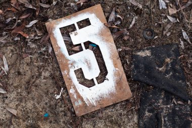 Yerdeki eski metal şablonda beş numara..