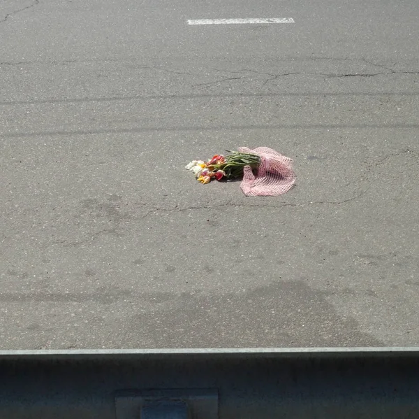 Bouquet of flowers on the road. Flowers on the asphalt surface.